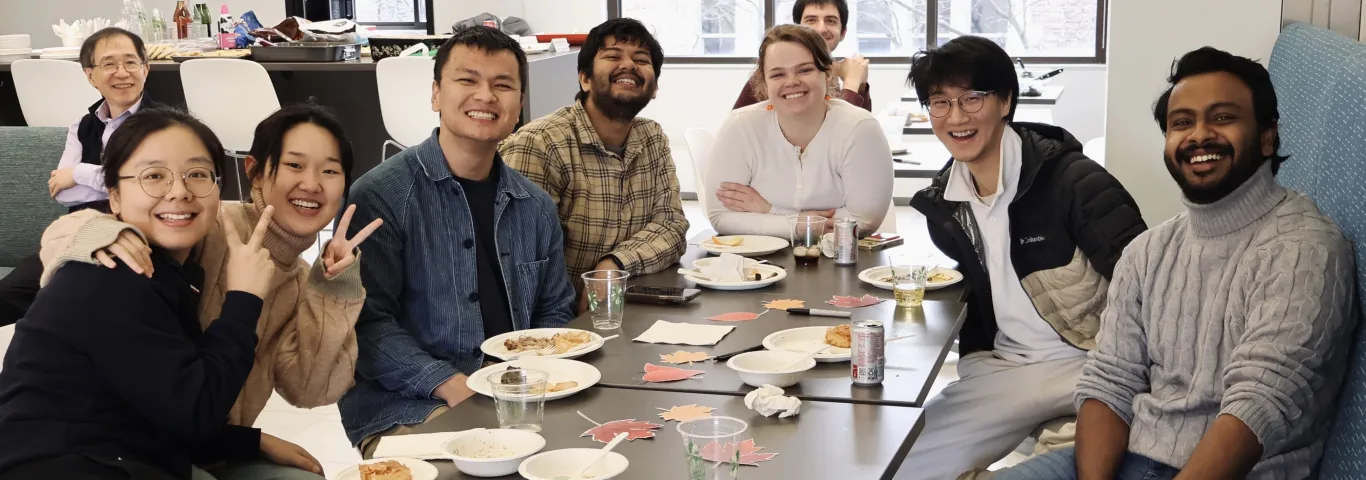 Nine people from the SDS department smile at the camera, surrounded by food