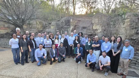 Group photo of all attendees at the St. Louis Zoo, in front of a rock wall